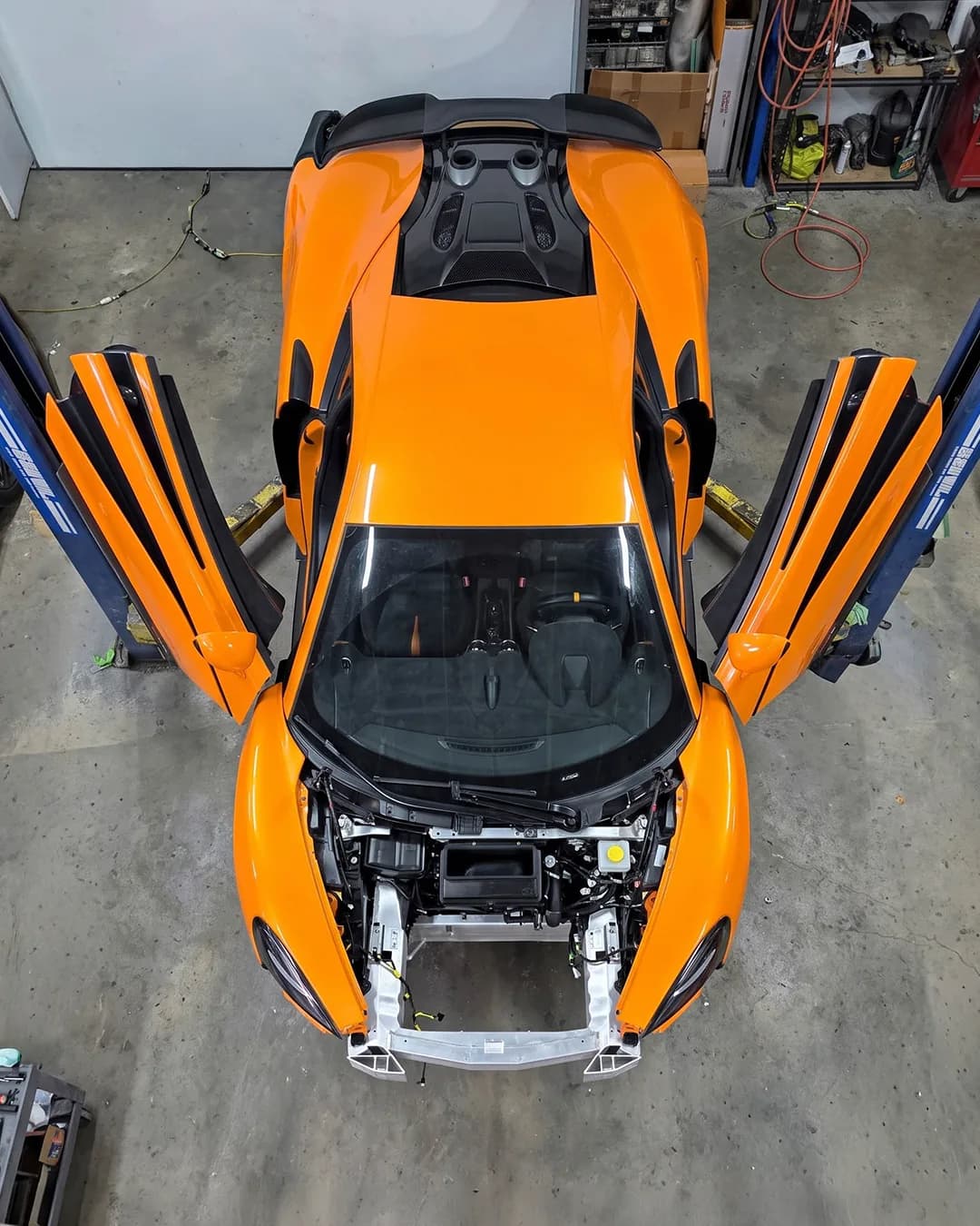 McLaren 570S disassembled on the lift for structural repair at HA Collision Repair, Boca Raton